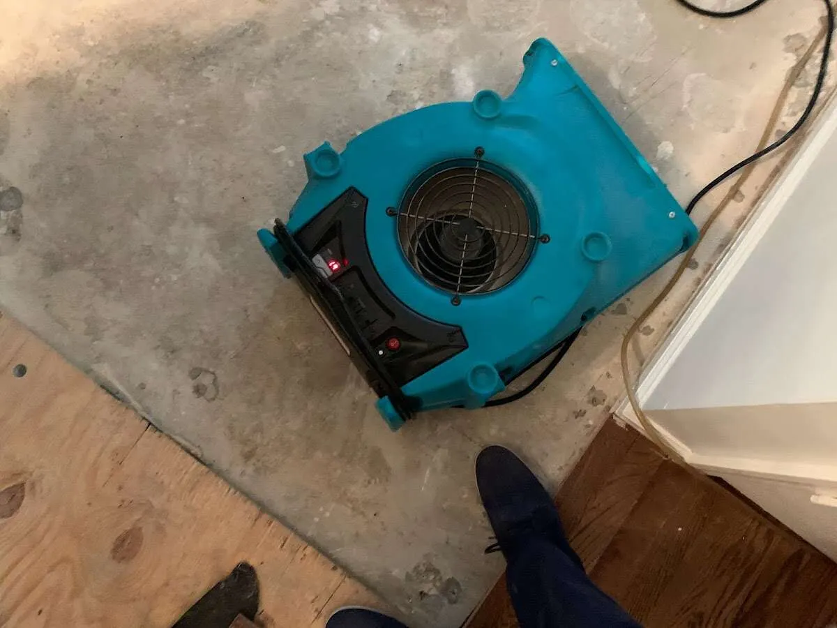 Air mover drying subfloor during Commercial Water Damage Restoration in Siloam Springs